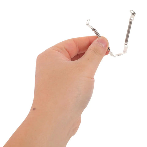 Hand holding Spring Loaded Tube Retainer Clip from Five Pack For Guitar Amps And Vintage Audio Gear Easy Install Metal Socket Retainers
