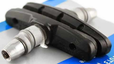 Trail-Ready M70T3 V-Brake Shoe Set for Mountain Bikes with cartridge style pads on a reflective surface