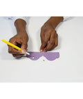 Hands using Pro Grade Cake Decorating Scriber Needle Tools on purple fondant template, marking detailed designs.