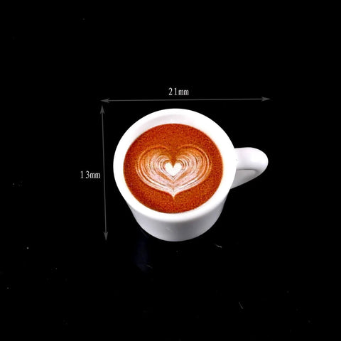 Top view of a white cup with heart latte art and dimensions 21mm x 13mm on black background.