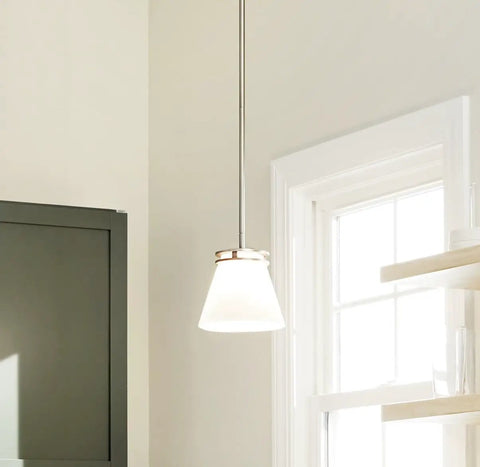 Sleek Brushed Nickel Mini Pendant Light With Satin Etched Opal Glass hanging by a window, warm ambient glow for kitchen island