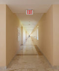 Led Emergency Exit Sign With Double Sided Capability Thermoplastic White Housing Red Letters NiCad Battery Backup in hallway