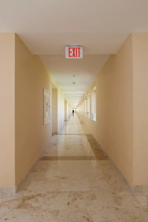 Led Emergency Exit Sign With Double Sided Capability Thermoplastic White Housing Red Letters NiCad Battery Backup in hallway