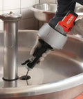 K-45AF Air Powered Drain Cleaner 230V Drum Auger being used on a stainless steel sink drain for sewer pipe clogs.