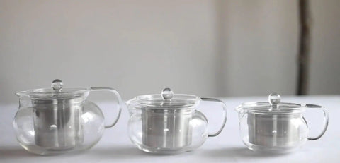 Three Kyoto 2-In-1 Tea Kettle And Tea Maker Glass Teapots with Removable Loose-Leaf Infusers on a white surface.