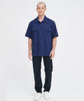 Men's Short Sleeve Work Shirt In Navy Blue Cotton Poly Blend Durable Button Front Uniform Features Double Chest Pockets Built Hella Tough For The Daily Grind And Extra Large Cut on a model standing against a plain background.