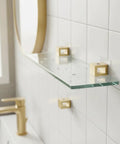 Solid Copper Glass Shelf Clip Surface Mount Bracket in bathroom, holds glass panel for floating shelf look, gold finish.