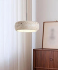 Modern Dome Yellow Travertine Pendant Light, Nordic Natural Stone Hanging Lamp above a wooden cabinet in bright room.