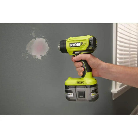 Person using 18V Cordless Heat Gun For Quick Heating Tasks Like Shrink Tubing And Paint Removal Up To 875 Degrees Fahrenheit With A Fast Under Ten Seconds Heat Up DIY Friendly Tool Only on wall