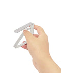 Hand holding heavy duty stainless steel tablecloth clip from the Heavy Duty Stainless Steel Tablecloth Clips Set Of 6 For Outdoor And Indoor Use Beefy Large Table Cover Clamps Holds Tablecloth Securely Up To 2 Inches Thick Durable Clamp Holders.