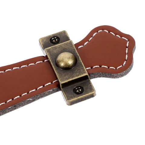 Close-up of vintage leather trunk handle replacement for cabinets and drawers, brown leather pull with brass hardware.
