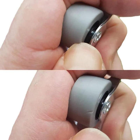 Close-up of 25 mm gray rubber caster wheel with metal mounting plate, held between fingers.