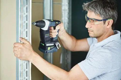 Man using Hardcore No Fuss Cordless Construction Screwdriver With Brushless Motor Tech on metal framing in a job site.