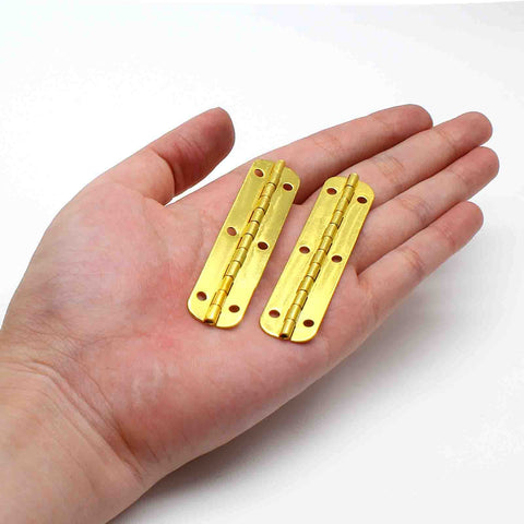 Pro Grade Mini Hinges 24 Pack Golden Finish 2 56 By 0 59 Inch Smooth Motion Hardware held in hand, showcasing iron construction.