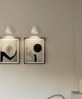 Modern Battery Powered Wall Sconces Set Of Two With Remote In White Wood Rotatable Dimmable Indoor Wall Lamps displayed above art pieces