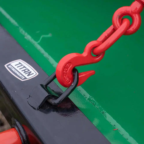 Close-up of red chain and hook on Hay Bale Spear Frame Attachment For Universal Front Loader Buckets Heavy Duty Skid Steer Loader 3000 Lb