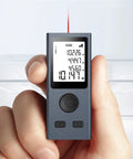 Heavy Duty Laser Rangefinder With Hella Accurate 98 Foot Digital Measurement Tool USB Rechargeable Battery HD Backlit Panel in hand.