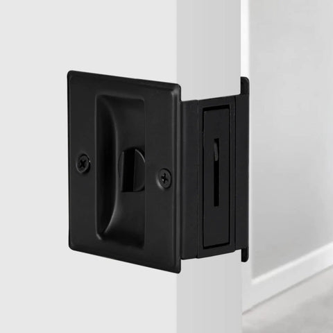 Premium Solid Brass Matte Black Pocket Door Lock Pull Set installed on a white door, durable sliding door lock for 1-3/8 inch doors.