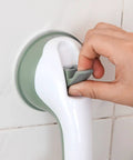 Hand adjusting a wall-mounted grab bar with suction cup attachment
