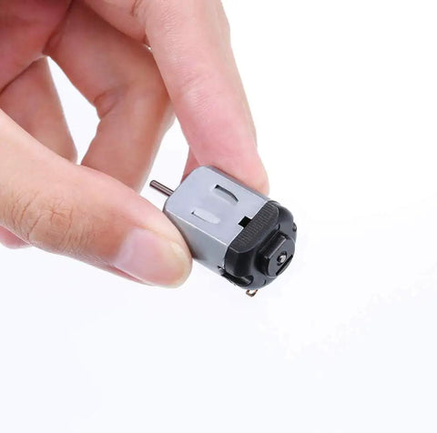 Close-up of hand holding Ultra Tiny High RPM Micro DC Motor Kit For DIY Projects 1.5 To 3 Volt Operation 16000 To 18000 RPM With Multicolor Wire.