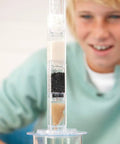 Boy using Hands-On Desalination Kit For Kids And Teens A Cool Lab Grade Science Toy with filtration layers in tube