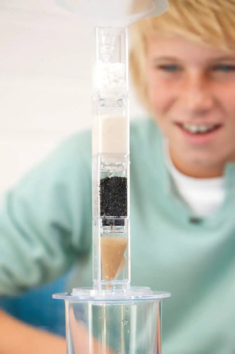 Boy using Hands-On Desalination Kit For Kids And Teens A Cool Lab Grade Science Toy with filtration layers in tube