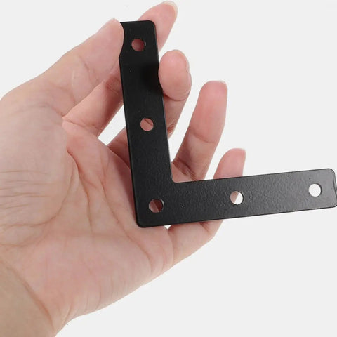 Hand holding Built To Last Heavy Duty Dark Steel L Shaped Corner Bracket With Pre Drilled Holes