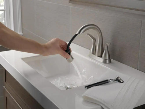 Person using Broadmoor Centerset Brushed Nickel Bathroom Faucet With Pull Down Sprayer, 4 Inch 3 Hole Sink Faucet in modern bathroom setting.