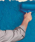 Person using Total Game Changer Eight Piece Paint Roller Corner Brush Kit for touchups on textured blue wall.
