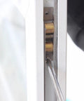 Close-up of Heavy Duty Double Wheel Sliding Door Roller And Replacement Window Pulley being installed with a screwdriver.