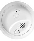 Top Shelf RV Approved Battery Powered Smoke Detector Featuring Precision Sensing To Slash Cooking Nuisance Triggers And Shield Your Rigs From Fire Hazards With A Gritty Tamper Proof Lock Pin For Unbeatable On The Road Peace Of Mind, round white smoke alarm with power button and sensor.