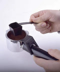 Hand using a black scoop to fill a silver portafilter with ground coffee for Semi Automatic Bean To Cup Coffee Maker With 5 Bar Pump And Auto Milk Frother Made Real Smooth For Home Espresso Shots Rich Cappuccino Sips Easy Cleanup And Everyday Grind Essentials.
