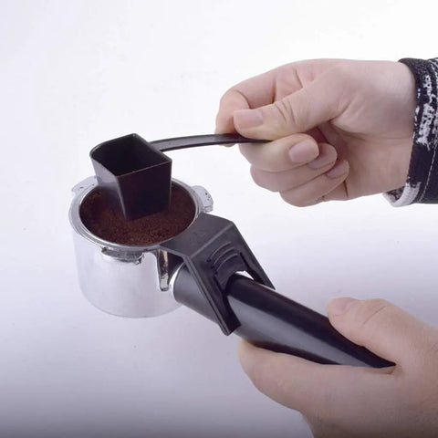Hand using a black scoop to fill a silver portafilter with ground coffee for Semi Automatic Bean To Cup Coffee Maker With 5 Bar Pump And Auto Milk Frother Made Real Smooth For Home Espresso Shots Rich Cappuccino Sips Easy Cleanup And Everyday Grind Essentials.