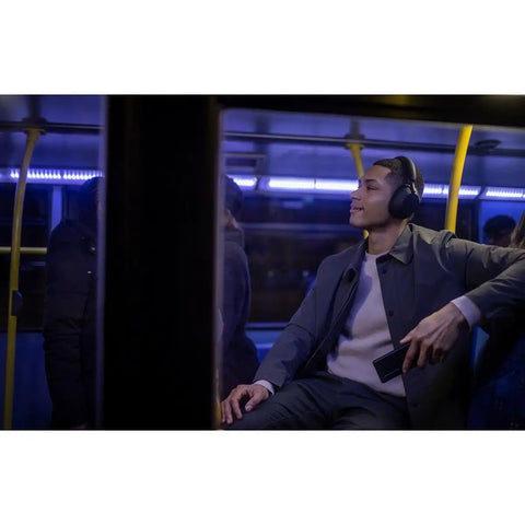 Person on a bus wearing WH-1000XM5 Premium Noise Canceling Headphones With Auto NC Optimizer All Day Battery Life Dope Sound
