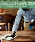 Person cleaning table with a towel, demonstrating 60 Pack 14x17 Inch White Bar Mop Towels Absorbent And Durable Terry Cloth Cleaning Rags