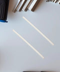 Two white PP plastic welding rods on a table, part of a 40 pack for car bumper repair DIY fix kit.