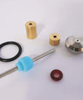 Waterjet on/off valve repair kit parts: brass bushings, steel valve stem with blue spacer, black O-ring, red gasket.