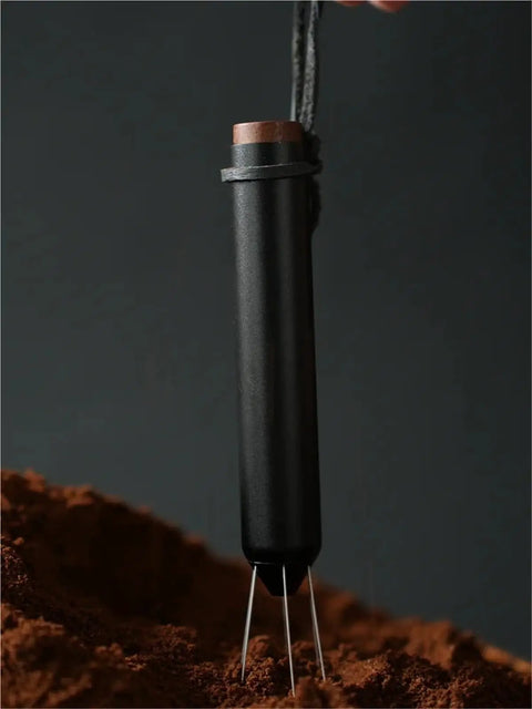 No Fuss WDT Needle Tool For Espresso Brewing Retractable Telescopic coffee ground distributor on brown coffee grounds.