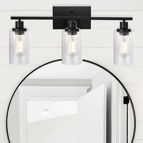 Three Light Matte Black Farmhouse Vanity Light With Seeded Glass Wall Sconce above bathroom mirror