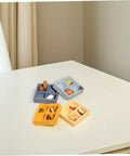 Four 4 Piece Miniature Storage Box for Dollhouse Resin Four Grid Organizer in assorted colors with candy and nuts on a table