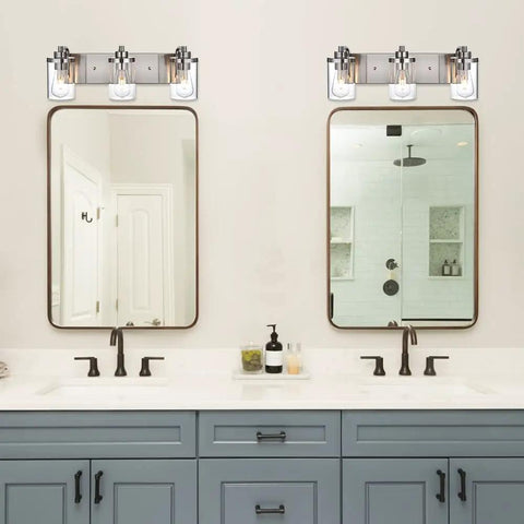 3 Light Vanity Bar Over Mirror With Brushed Nickel Finish And Clear Glass Shades Above Dual Bathroom Mirrors