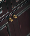 Antique Brass Cabinet Knobs With Gear Like Backplate Six Pack installed on dark cabinet, highlighting vintage round cup design.