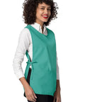 Heavy Duty Cobbler Apron 3 Pack For Men And Women In Bold Surgical Green with deep pockets, worn by a smiling woman.
