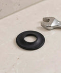10pcs Rubber Bathtub Drain Stopper Gasket Black, Elastic Seal Washer on a countertop next to a wrench.