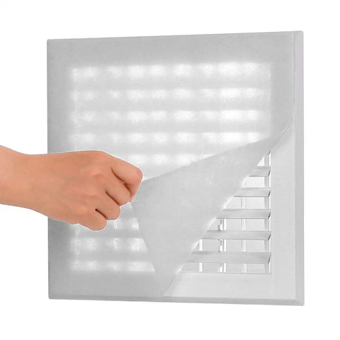 Hand applying DIY air vent filter to HVAC grille with Complete Air Vent Filter Kit For Your HVAC And Home Ducts, DIY Friendly.
