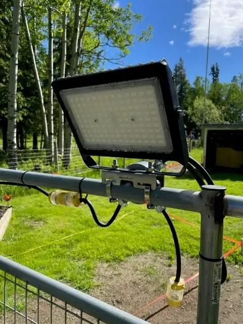 Junction Box Pipe Mount Bracket With Adjustable Clamps For Pole Or Wall Installations holding a light fixture outdoors