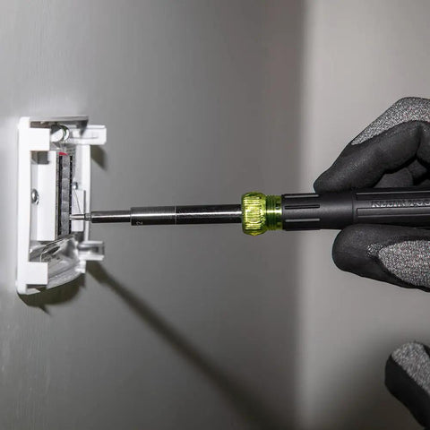 14-In-1 Electronic Precision Screwdriver Kit with 8 Tips being used to tighten a screw in an electrical panel.