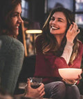 Two people enjoy ambient light from a Go White And Color Portable Dimmable LED Smart Light Table Lamp That Plays Nice With Alexa.