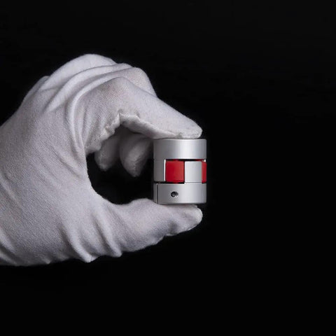 Beefy Durable Aluminum Flexible Shaft Coupling D25 L30 For 5 To 8mm Shafts in gloved hand, showing red dampening element.