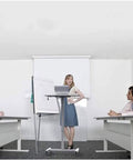 Hella Sturdy Height Adjustable Mobile Standing Desk With Smooth Glide Casters And Rustproof White Steel Top Portable Laptop Workstation And Rolling Podium For Home Office Space in a meeting room with presenters and attendees.